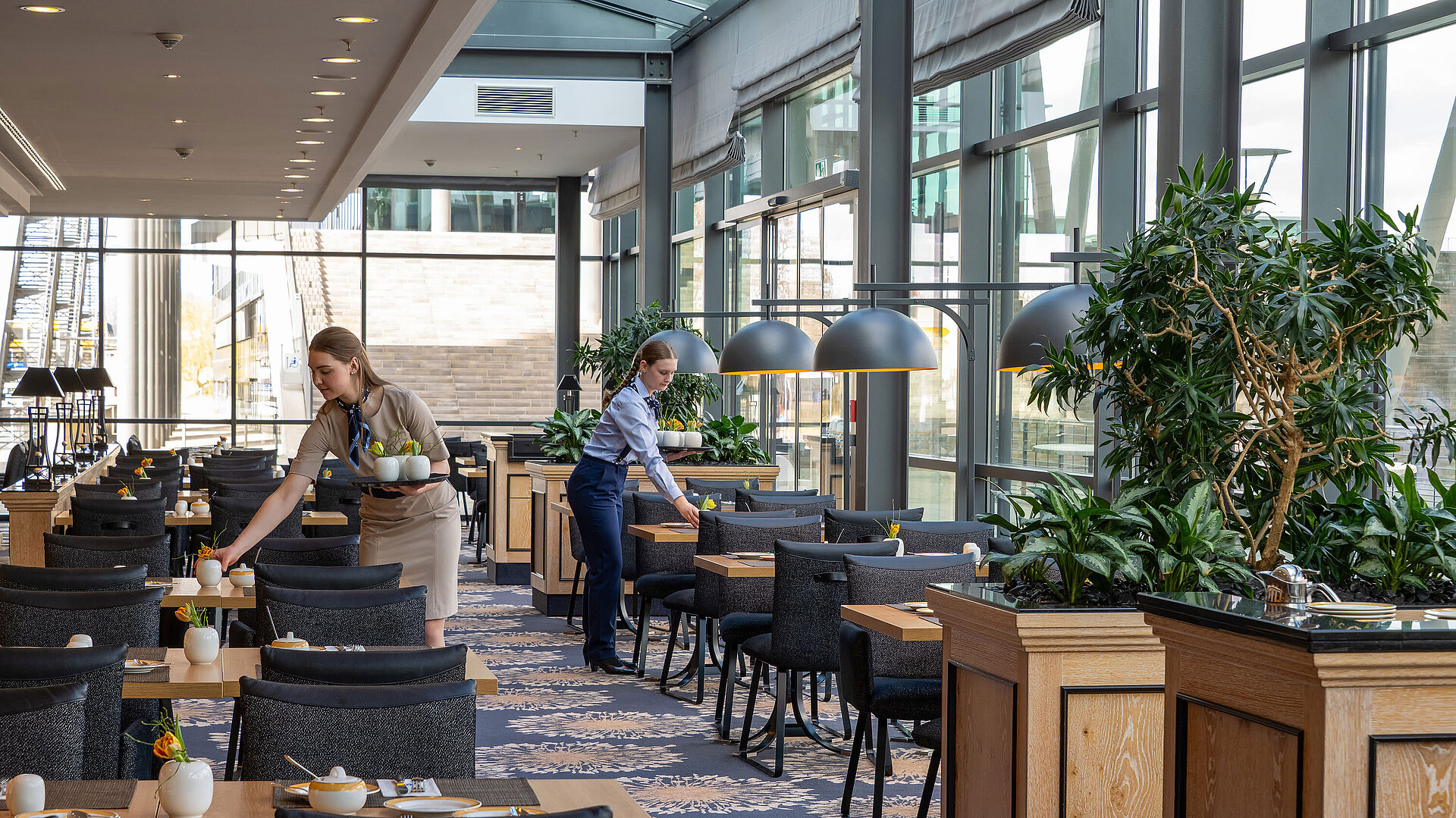 Ristorante Wintergarten Interno luminoso del ristorante Wintergarten del Maritim Hotel Dresden con grandi finestre e tavoli apparecchiati.