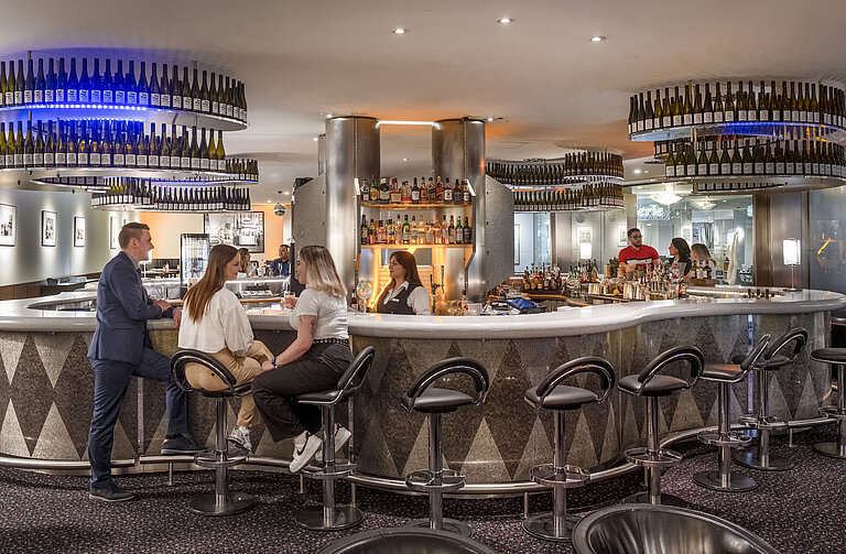 Elegant bar at Maritim proArte Hotel Berlin where guests enjoy relaxed conversations and a wide selection of drinks.