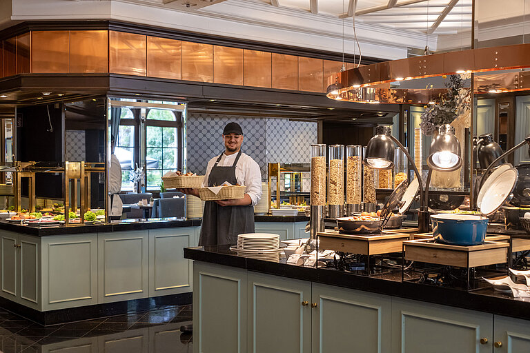 Ristorante Landgraf Un membro dello staff al buffet della colazione nel Ristorante Landgraf, Maritim Hotel Darmstadt, con prodotti da forno