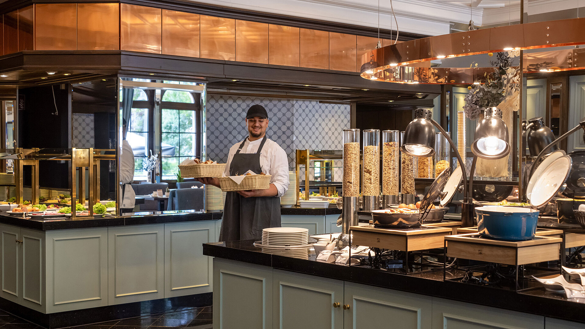 Empleado en el bufé de desayuno del Restaurante Landgraf, Maritim Hotel Darmstadt, con bollería fresca