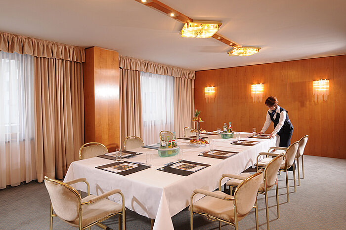 Salle de conférence élégante à l'hôtel Maritim Magdebourg avec une table dressée et un service.