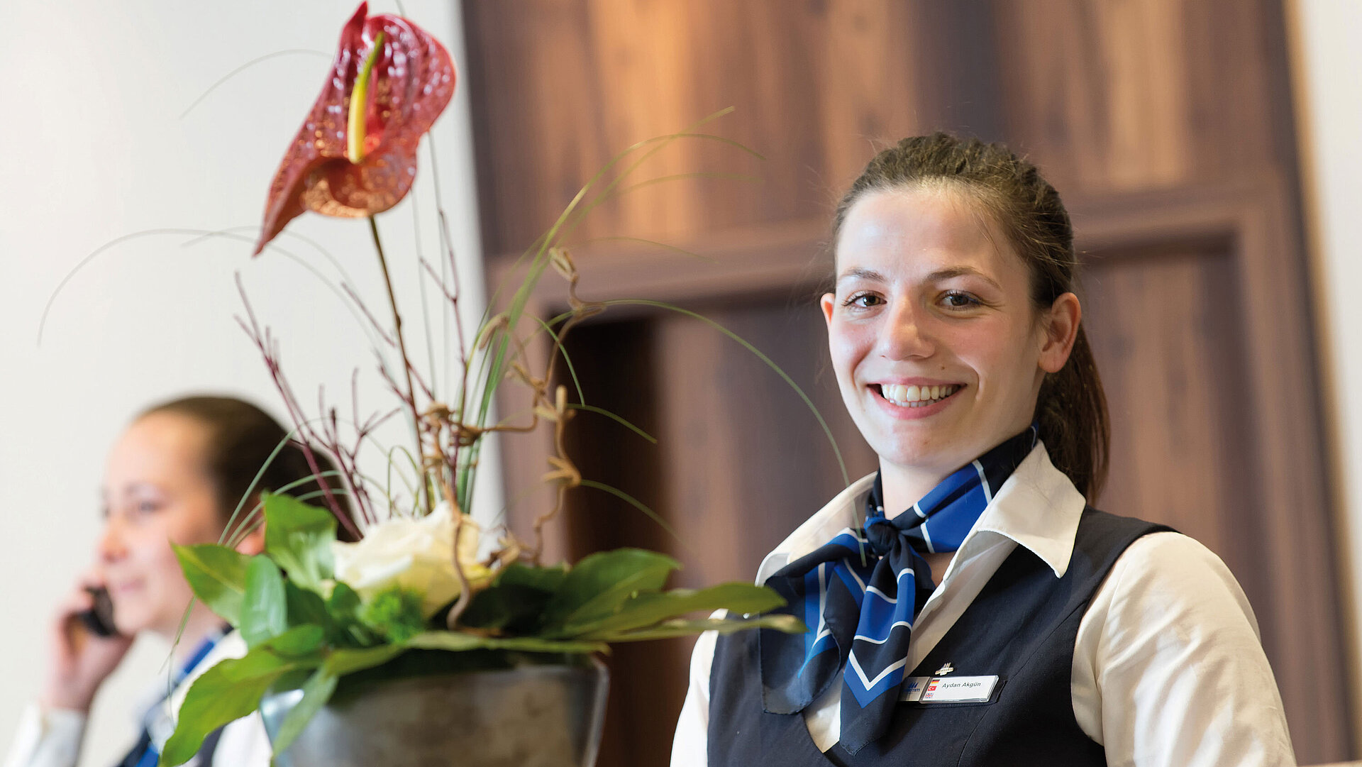 Receptionist cordiale al Maritim Hotel Titisee con decorazione floreale
