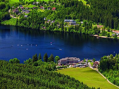Vista aérea del hotel Maritim junto al lago Titisee con bosque y botes a pedales