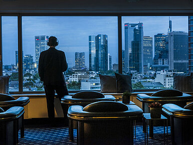Guest enjoying the panoramic view of Frankfurt’s skyline in the Sky Lounge at Maritim Hotel Frankfurt.