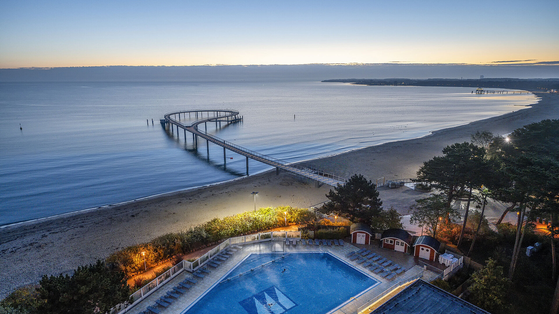 Evening view of the pier and illuminated pool at the Maritim Seehotel in Timmendorfer Strand.