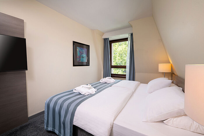 Junior Suite Bedroom of the Junior Suite at Maritim Hotel Königswinter with a double bed, window and bright interior.