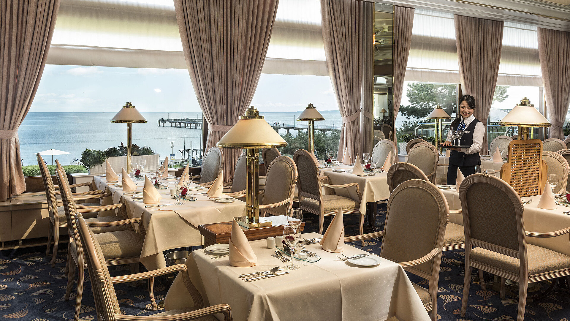 Restaurant élégant avec vue sur la mer et tables dressées au Maritim Seehotel Timmendorfer Strand.