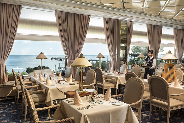 Restaurant élégant avec vue sur la mer et tables dressées au Maritim Seehotel Timmendorfer Strand.
