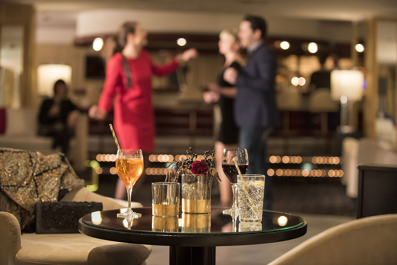 Table with cocktails and drinks while guests dance at the bar of Maritim Seehotel Timmendorfer Strand.