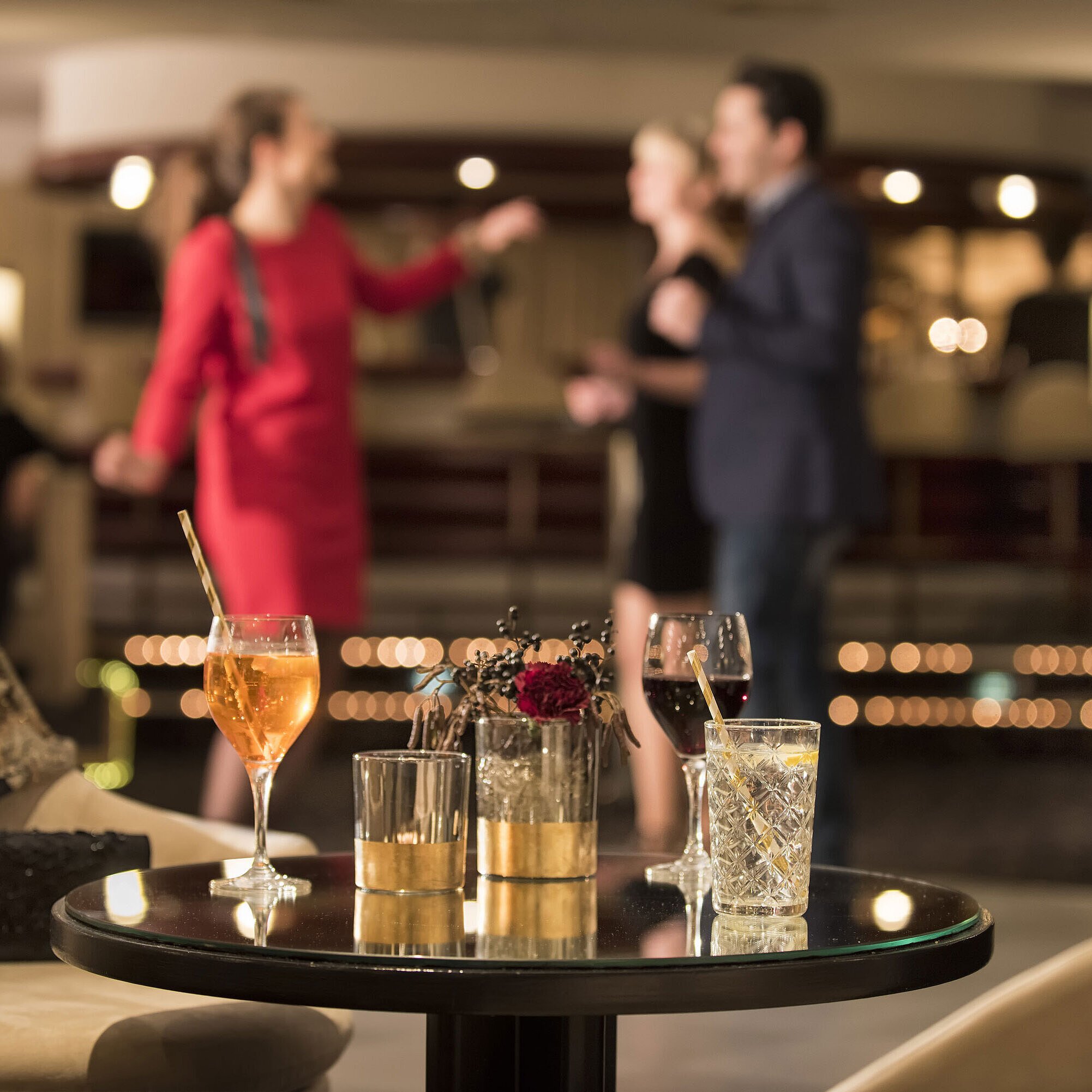 Table with cocktails and drinks while guests dance at the bar of Maritim Seehotel Timmendorfer Strand.