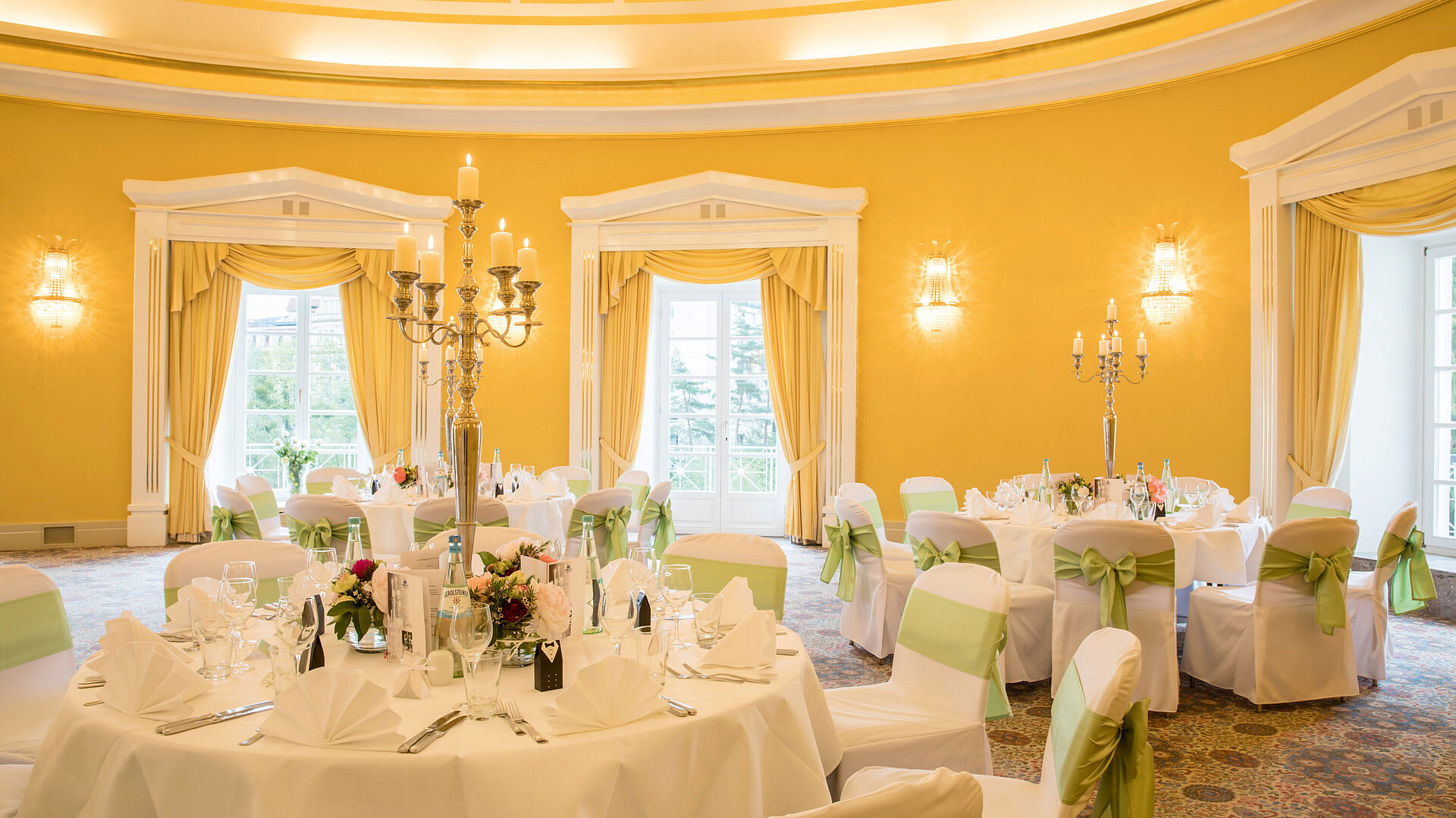 Salón con fundas blancas y lazos verdes para bodas en el Maritim Hotel Bad Wildungen