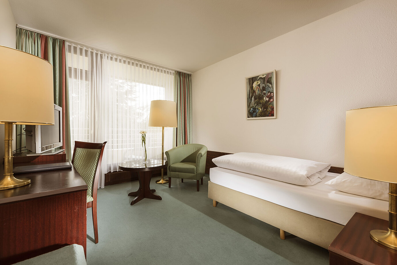 Camera chiara con finestra, scrivania e poltrona al Maritim Hotel Bad Salzuflen