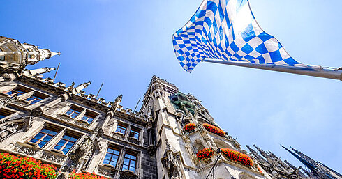 Bavarian flag above Marienplatz with historic town hall in Munich