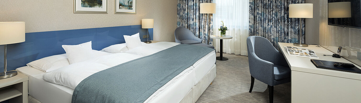 Habitación Superior en el Hotel Maritim Bonn con diseño elegante, camas cómodas, escritorio moderno y acogedora zona de estar.