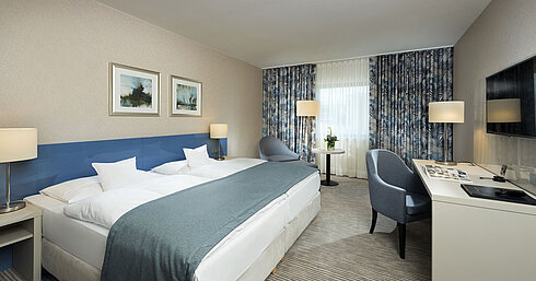 Habitación Superior en el Hotel Maritim Bonn con diseño elegante, camas cómodas, escritorio moderno y acogedora zona de estar.