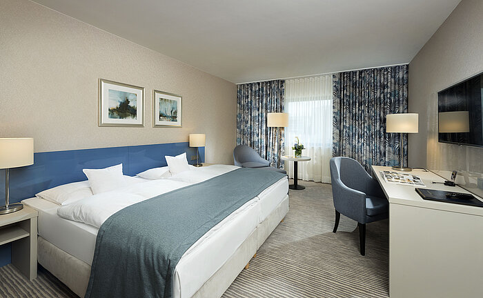 Habitación Superior en el Hotel Maritim Bonn con diseño elegante, camas cómodas, escritorio moderno y acogedora zona de estar.