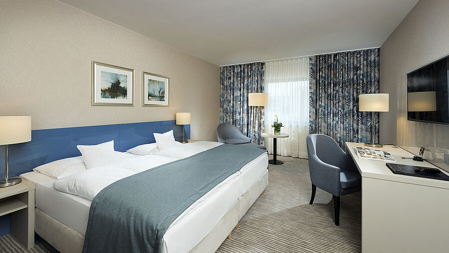 Habitación Superior en el Hotel Maritim Bonn con diseño elegante, camas cómodas, escritorio moderno y acogedora zona de estar.
