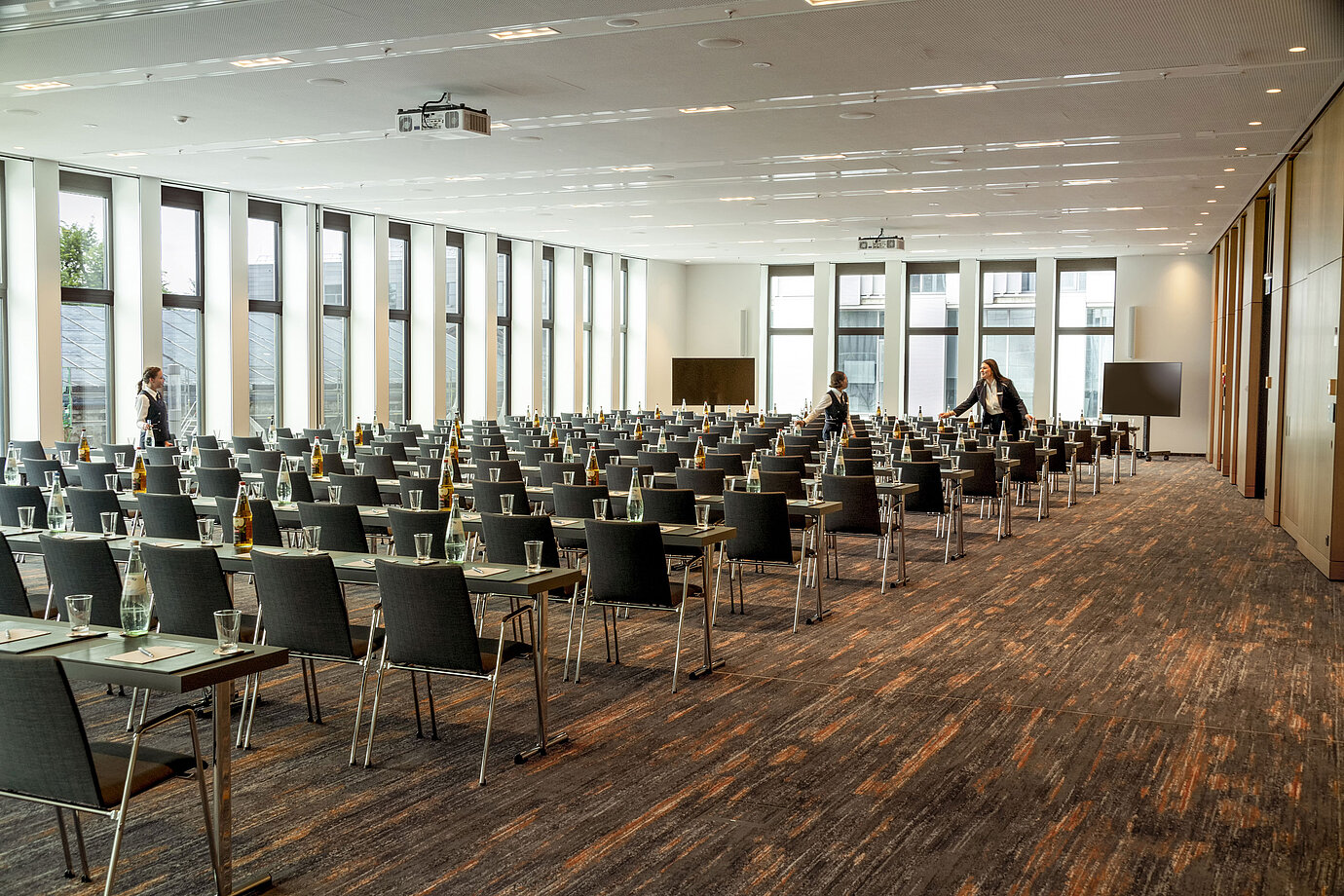 Salle de conférence de l'hôtel Maritim Ingolstadt avec sièges en rangée, technologie moderne et fenêtres lumineuses.