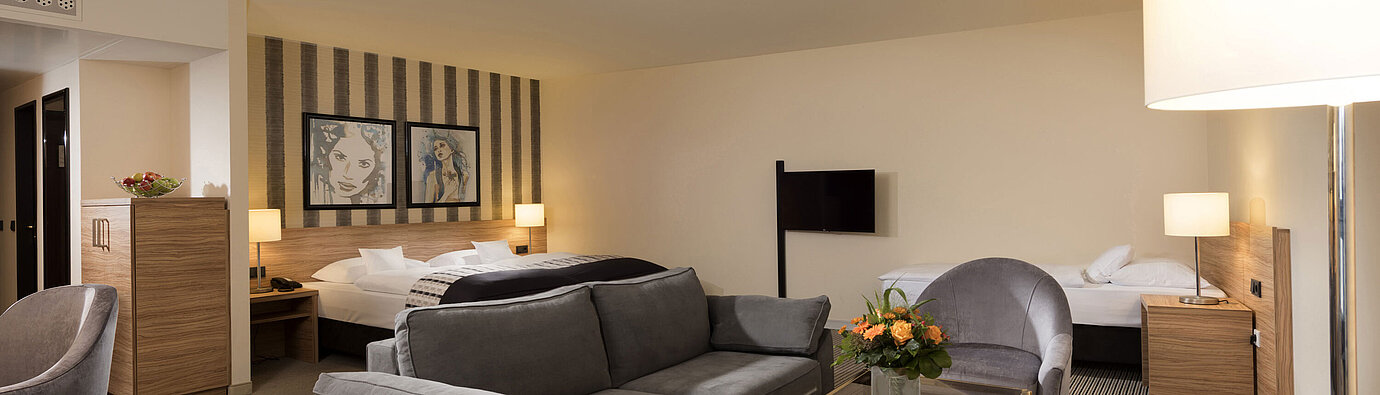 Spacious family room at Maritim Hotel Königswinter with seating area and stylish design.