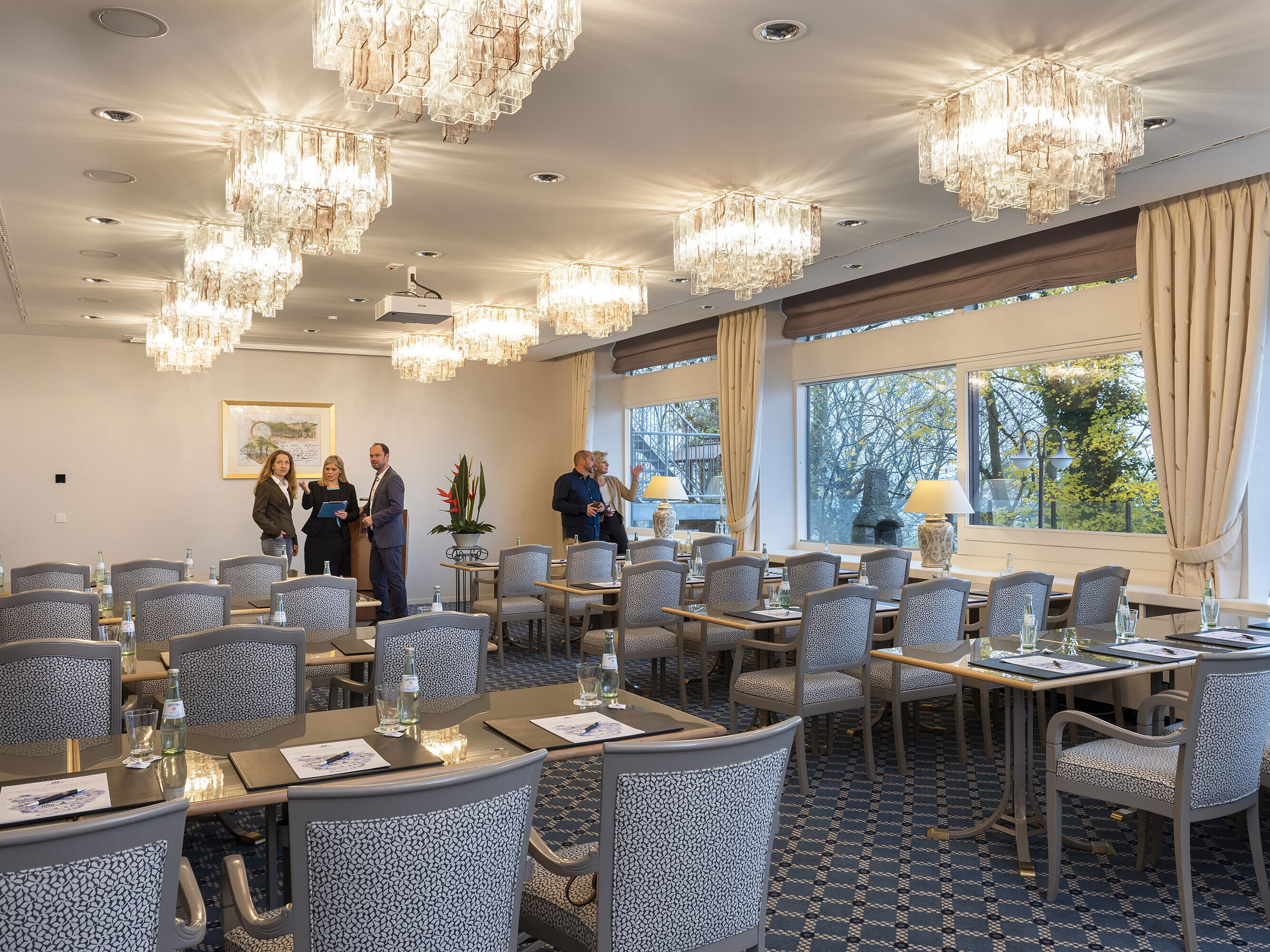 El Salón Copenhague del Maritim Hotel Kiel es una elegante sala de conferencias con lámparas de araña, mesas tendidas y grandes ventanales.