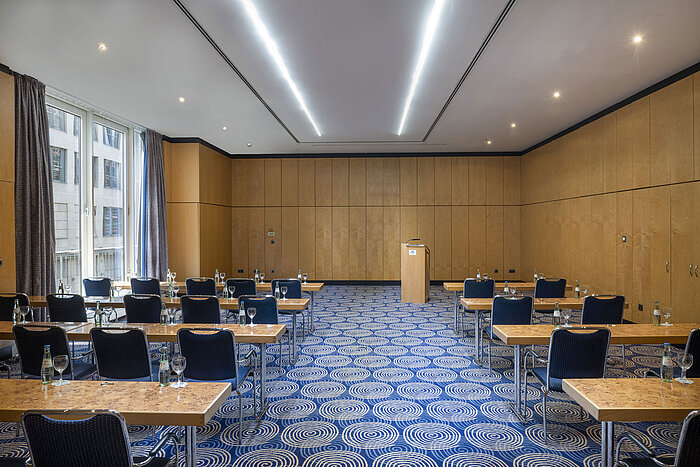 Salle de réunion Salon IV du Maritim proArte Hotel Berlin avec tables, chaises et pupitre.