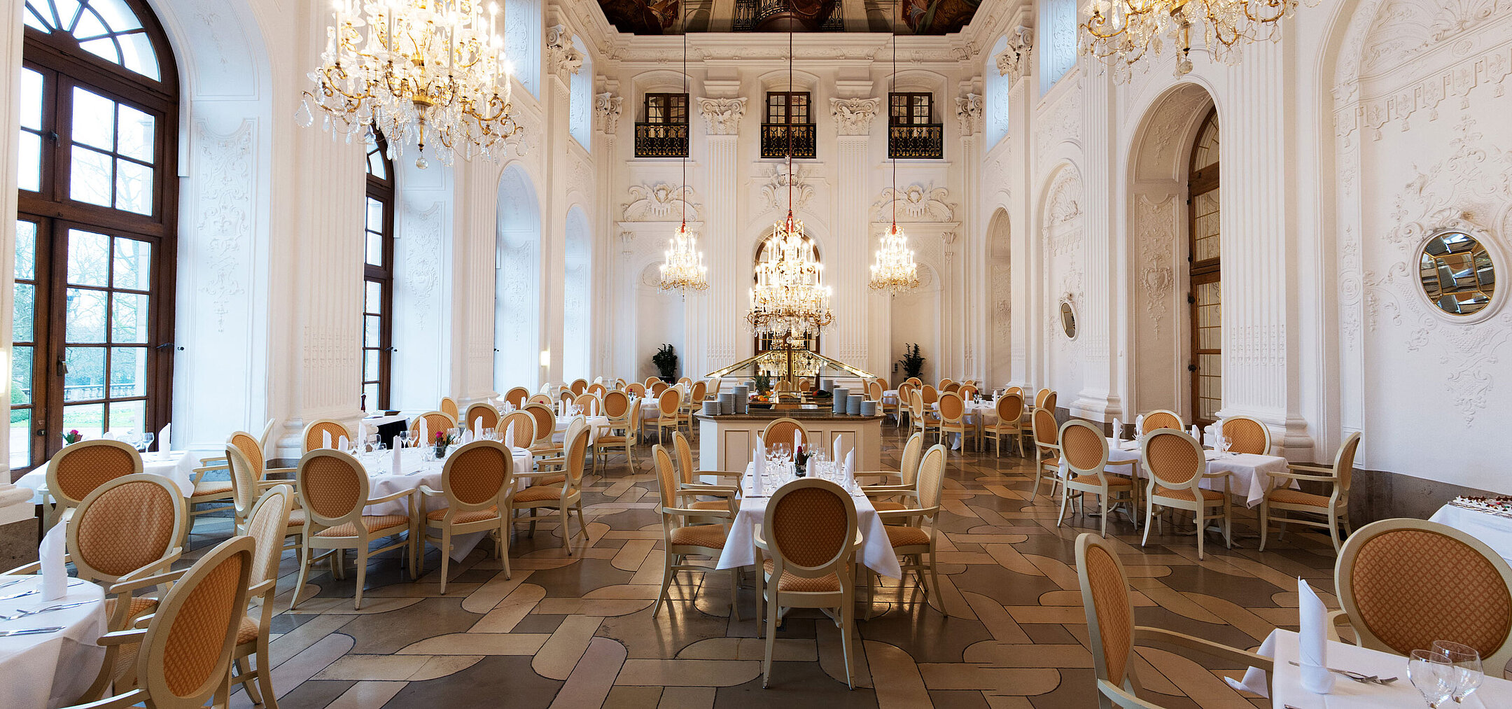 Élégante salle Apollo au Maritim Hotel Fulda avec lustres, plafond à fresques et tables raffinées.