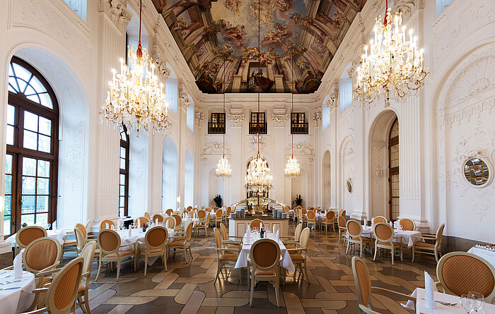 Élégante salle Apollo au Maritim Hotel Fulda avec lustres, plafond à fresques et tables raffinées.