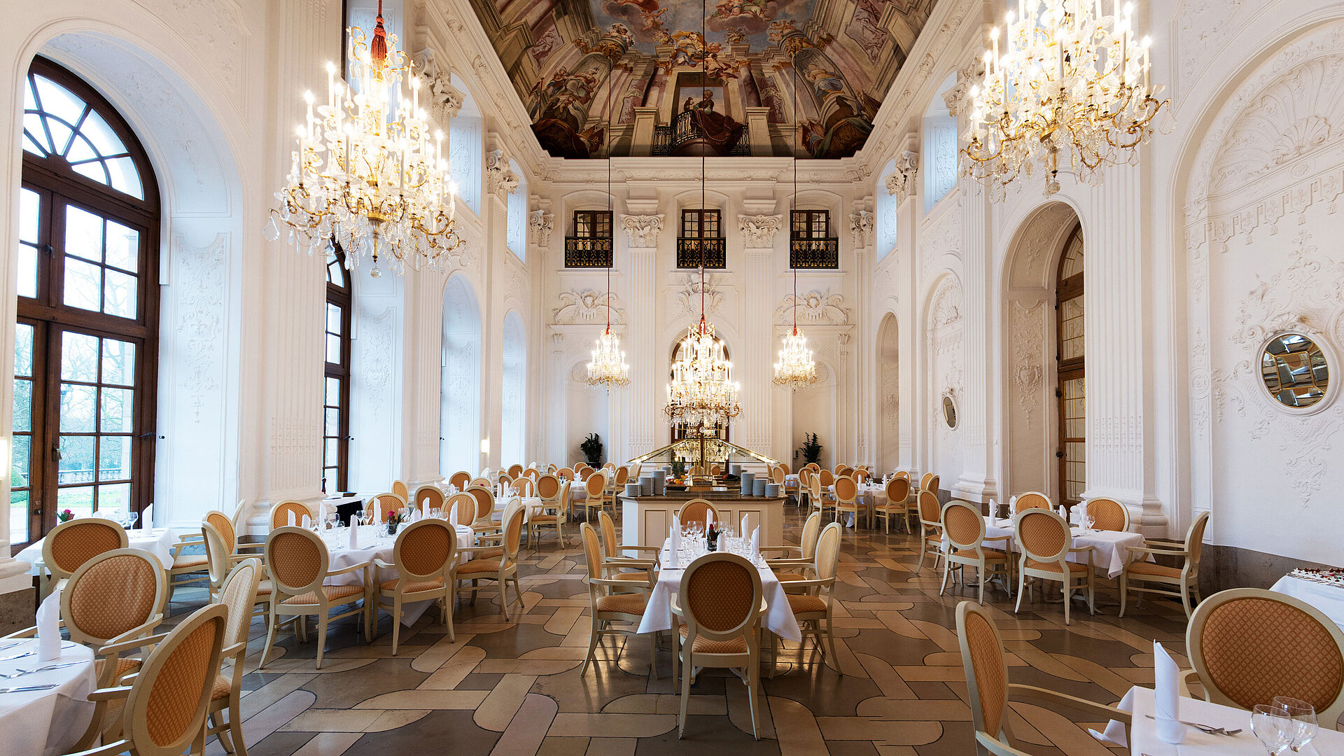 Élégante salle Apollo au Maritim Hotel Fulda avec lustres, plafond à fresques et tables raffinées.