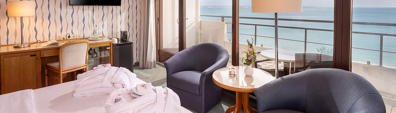 SuperiorPlus room facing the sea with seating area, double bed and balcony overlooking the Baltic Sea