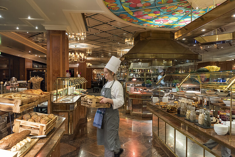 Breakfast buffet at Maritim Hotel Bremen with fresh bread rolls, bread,and a selection of breakfast dishes,attended by a chef