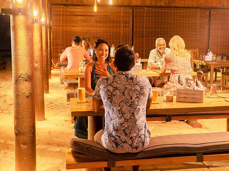 Restaurant Les Filaos Guests enjoying a social dinner in an open restaurant with warm lighting