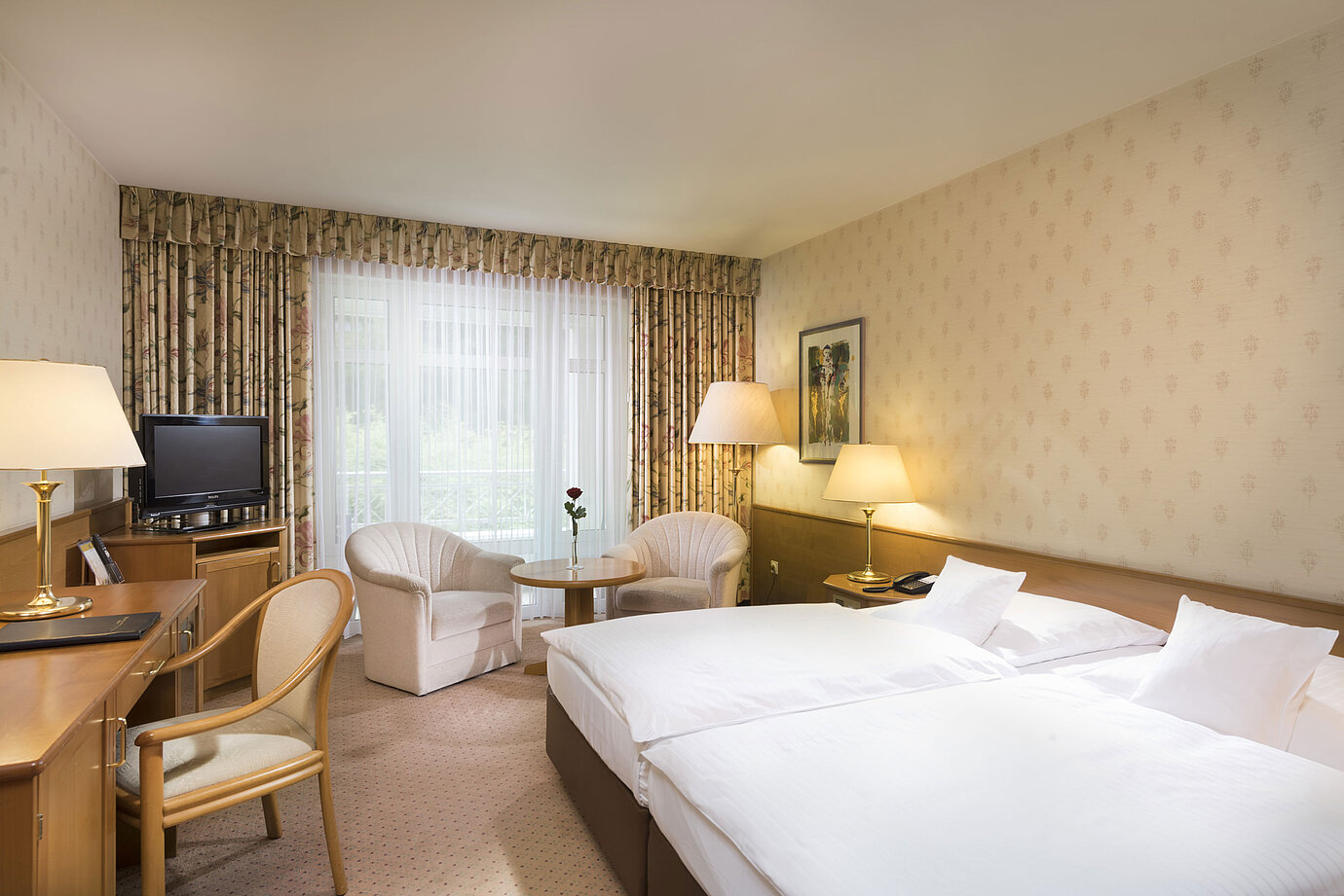 Bright double room with seating area and desk at Maritim Hotel Bad Wildungen