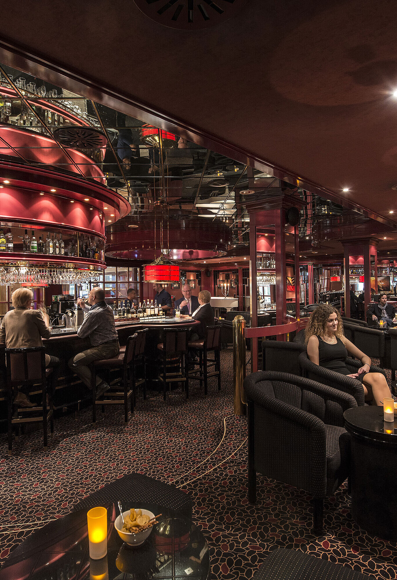 Clients savourant des boissons dans le bar rouge élégant de l’hôtel Maritim