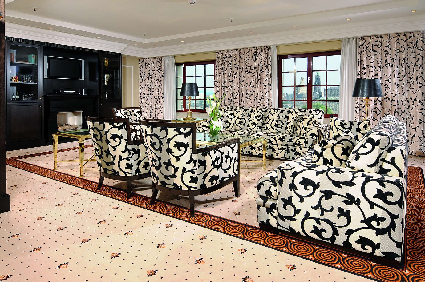 Presidential suite at the Maritim Hotel Dresden with stylish sofas, armchairs, and city view.