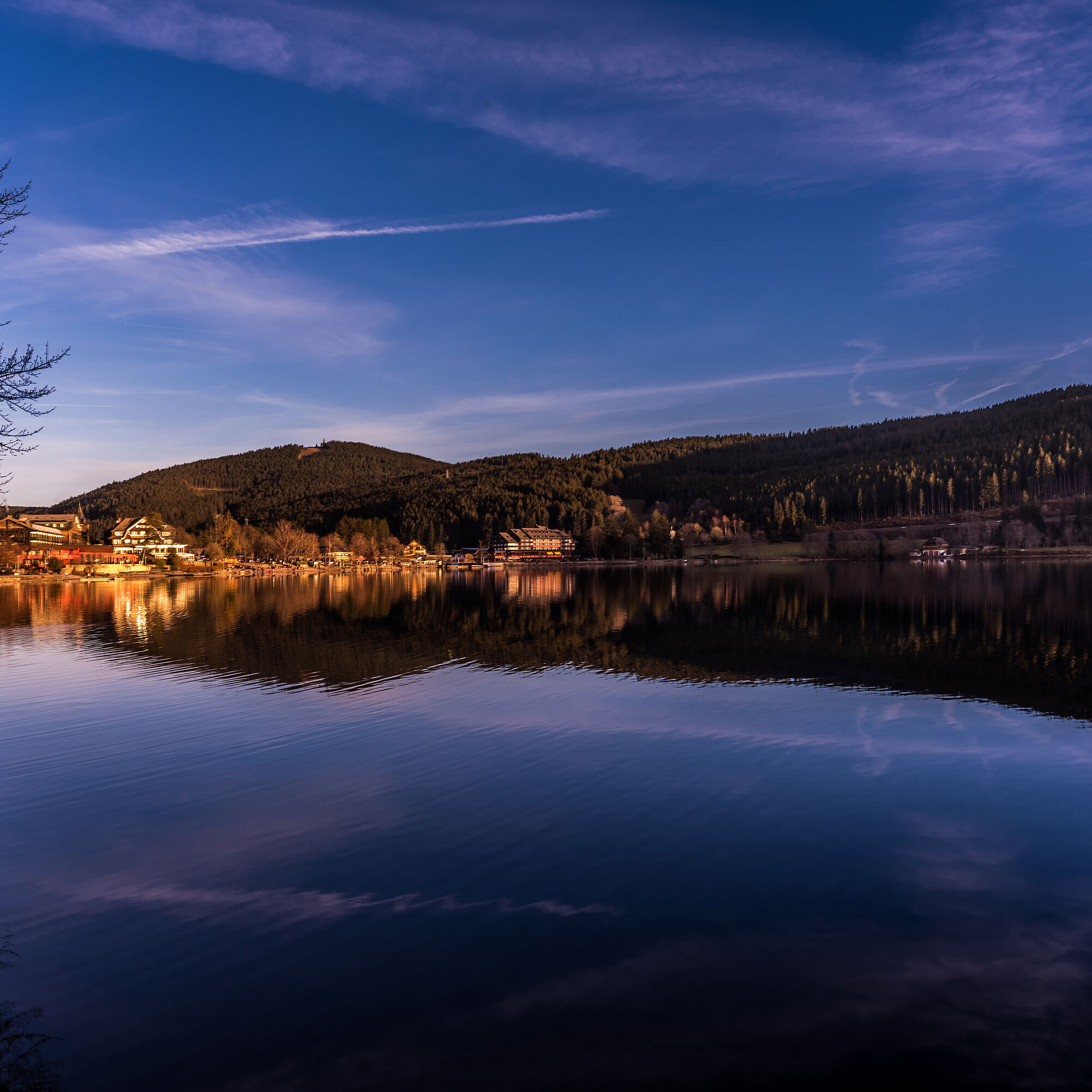 Sunset view over Lake Titisee with reflection of Maritim Hotel on the water