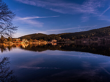 Sunset view over Lake Titisee with reflection of Maritim Hotel on the water