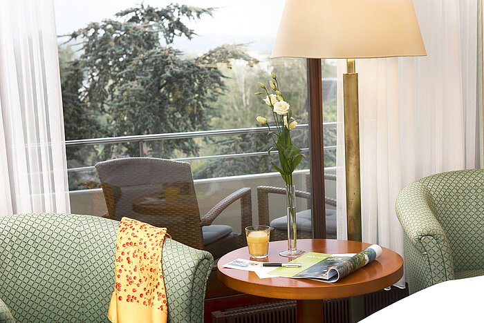 Accogliente zona salotto al Maritim Hotel Bad Salzuflen con vista sul balcone e sul verde