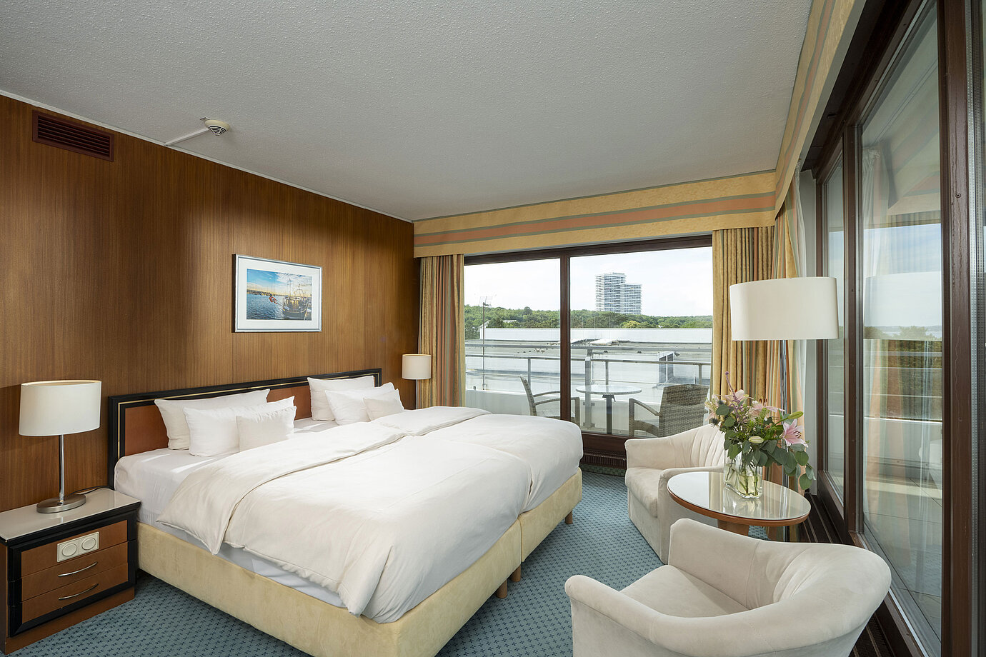 Spacious family suite at Maritim Seehotel Timmendorfer Strand with balcony, sea view, and cozy seating area.