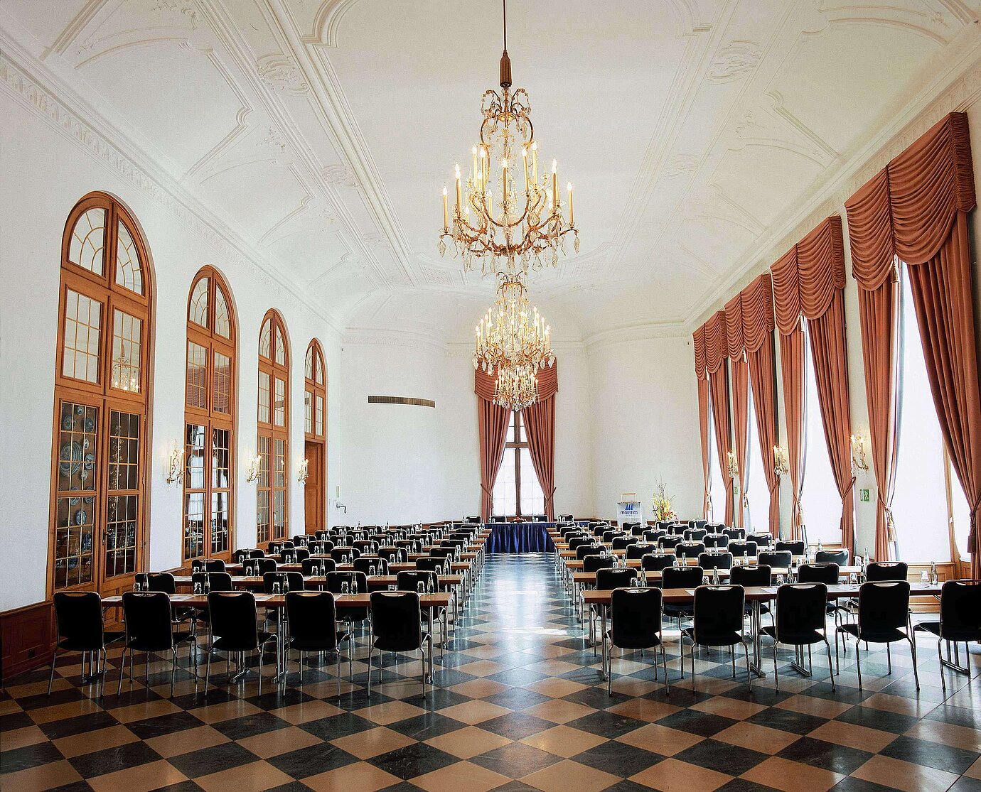 Salle d’événement élégante au Maritim Hotel Fulda avec lustres, hautes fenêtres et sièges raffinés pour événements.