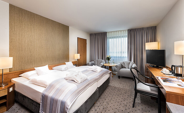 Habitación doble Superior con cama king-size, albornoces, zona de estar y escritorio en Maritim Hannover.