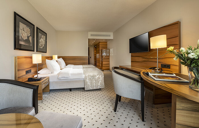 Habitación confort en el Maritim Hotel Bad Homburg con cama doble, decoración de madera elegante y comodidades modernas.