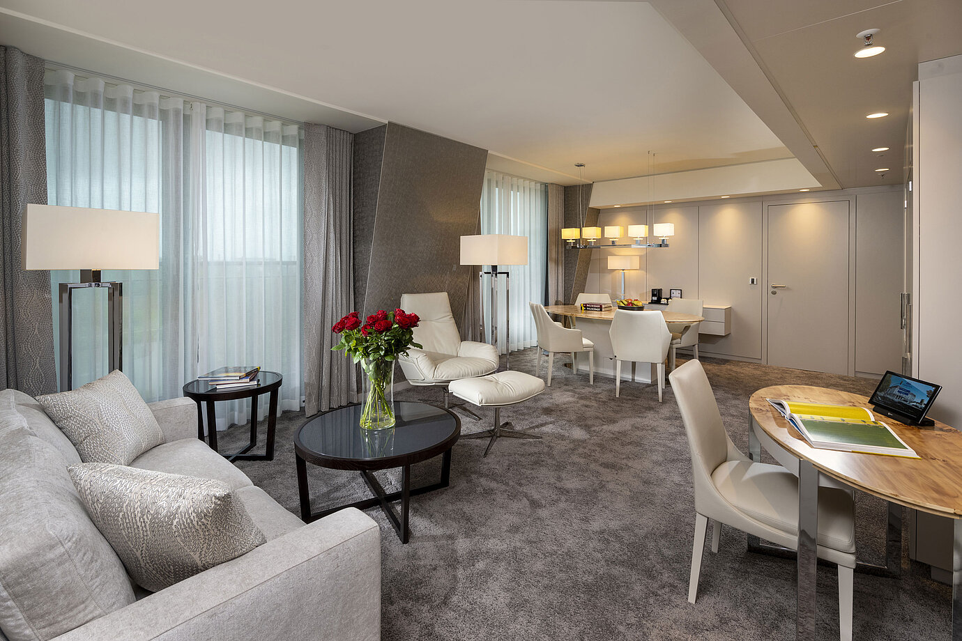 Premium suite with elegant interior, seating area, dining table, and sophisticated decor.