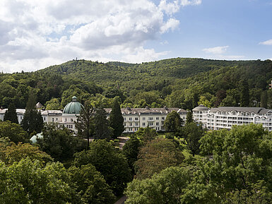 Exterior view of Maritim Hotel Bad Wildungen surrounded by lush greenery in summer
