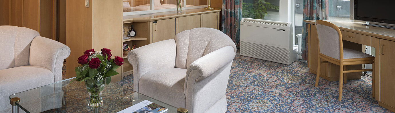 Winter garden suite  Stylish living area with armchairs, TV, large windows and roof view at Maritim Hotel Bad Wildungen
