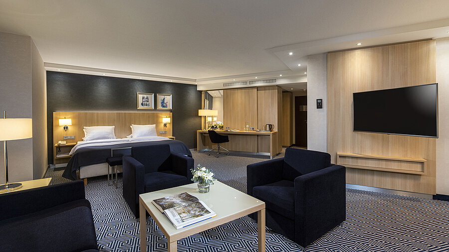 Amplia Junior Suite en el Maritim Hotel Würzburg con cama doble y zona de estar acogedora