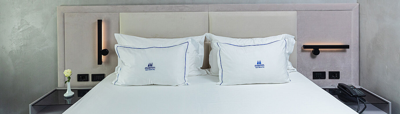 Letto matrimoniale moderno al Maritim Resort Marina Bay con testiera elegante e cuscini