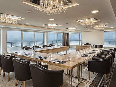 Salón Hamburgo en Maritim Seehotel Timmendorfer Strand, sala de reuniones con vista al mar, mesa en L y luces elegantes.