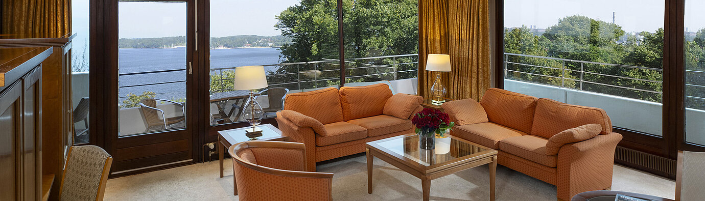 Salon lumineux de la suite présidentielle de l'hôtel Maritim Kiel avec vue panoramique sur la mer Baltique et meubles élégants