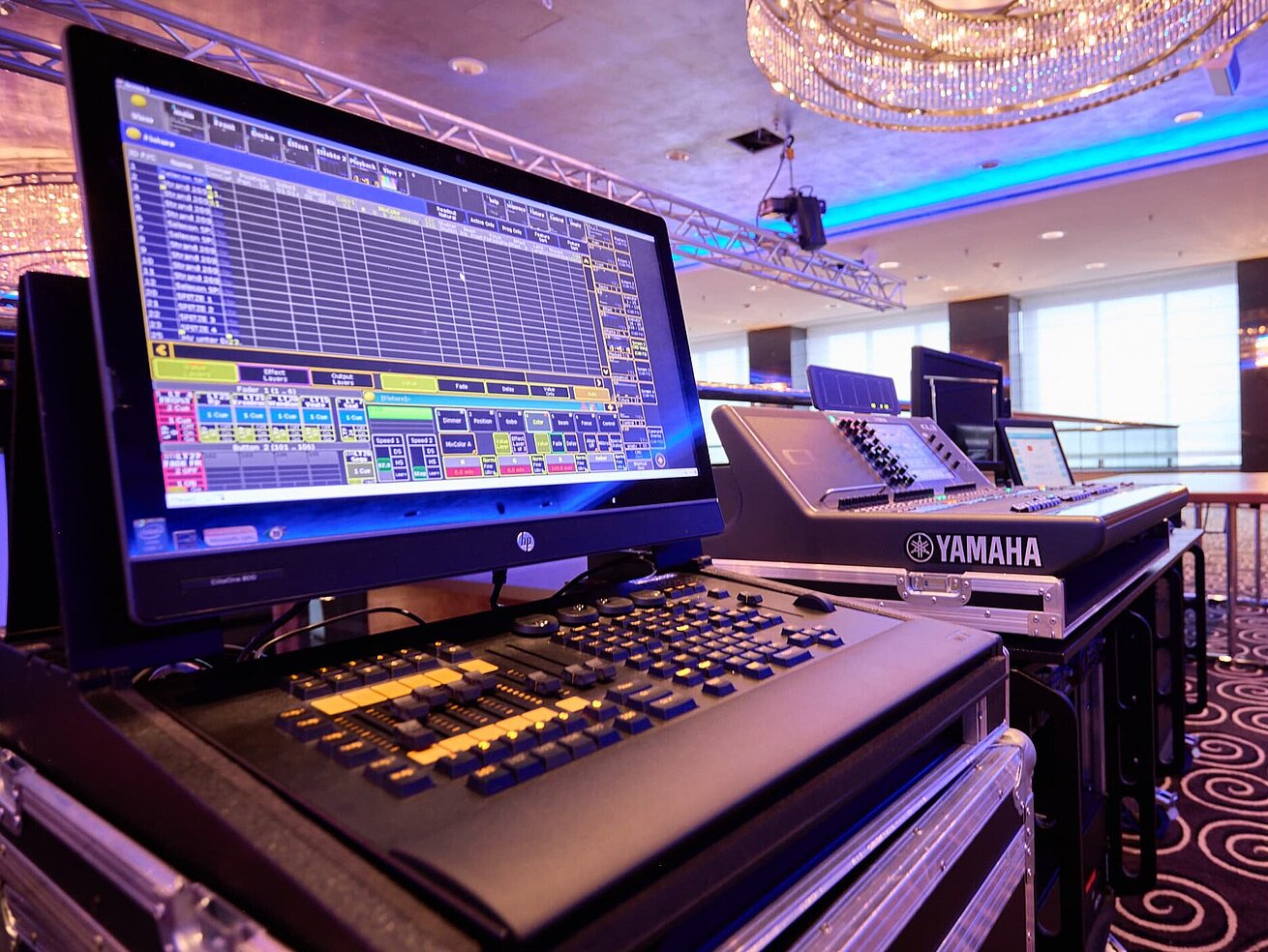 Tecnologia per eventi in sala moderna Console luci e mixer professionali in una sala eventi moderna con allestimento palco.