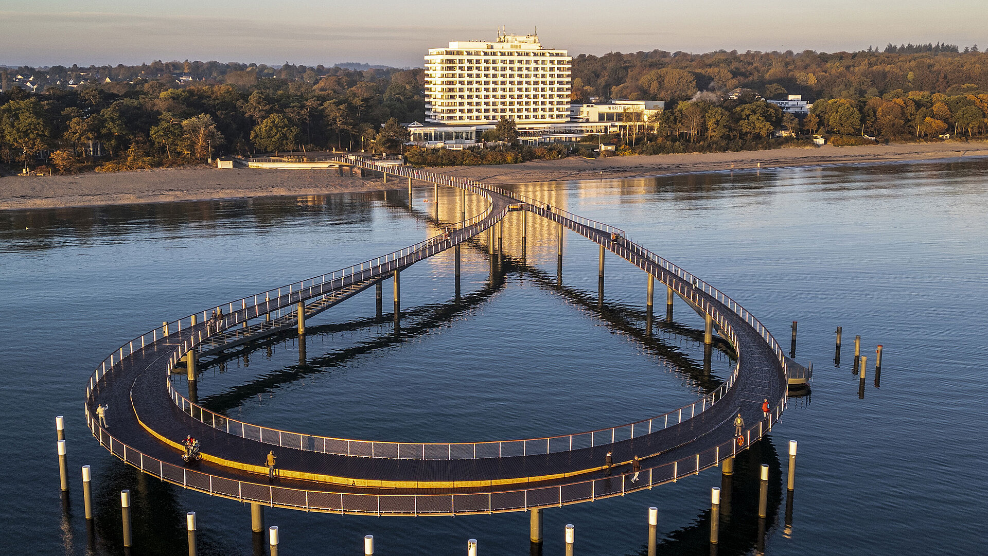 Illuminated pier at dusk in front of the Maritim Seehotel Timmendorfer Strand.